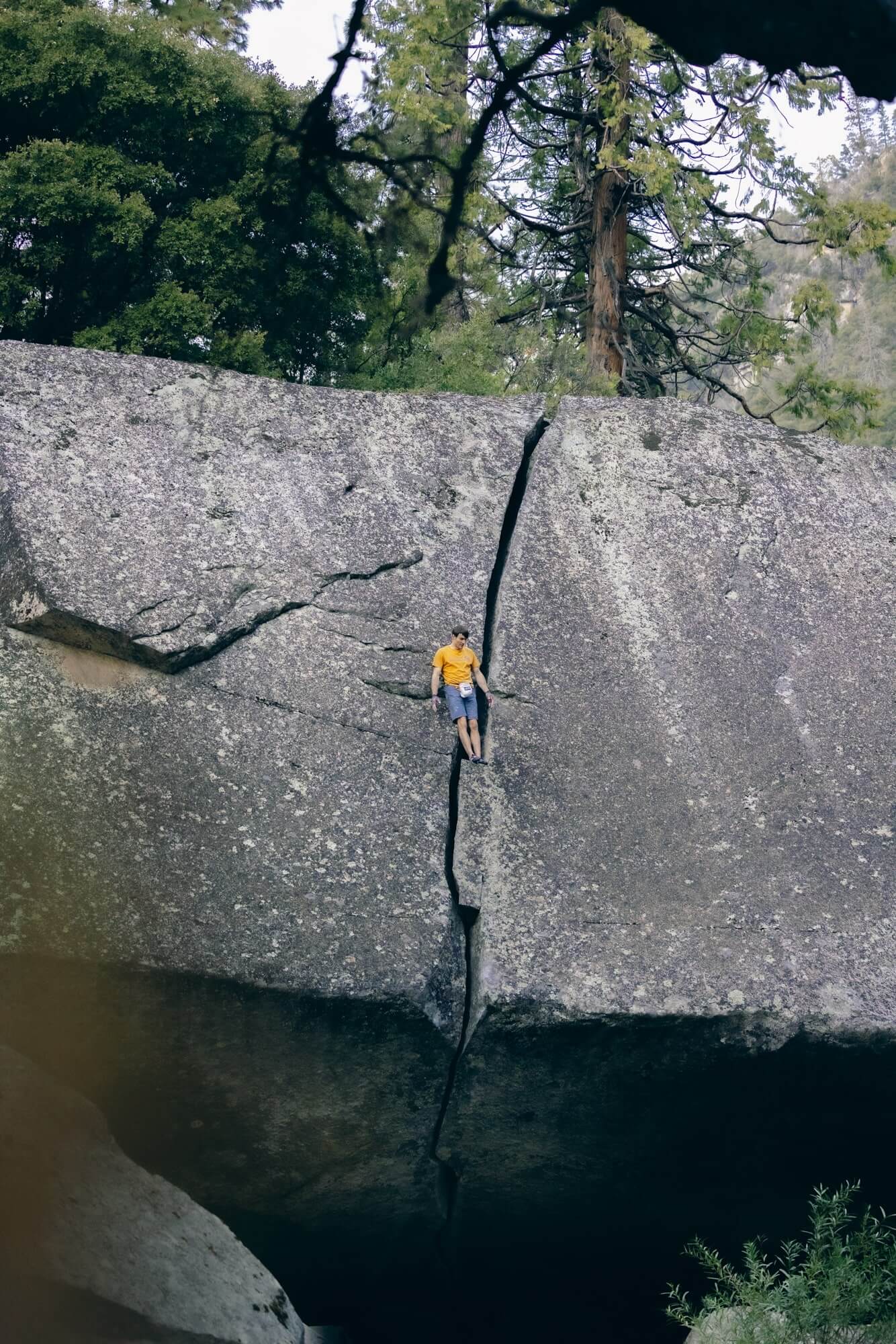 Ethan Pringle standing with his back against the wall on the middle of a boulder